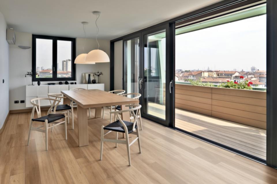 luxury vinyl plank flooring in dining room with black floor to ceiling windows and balcony.